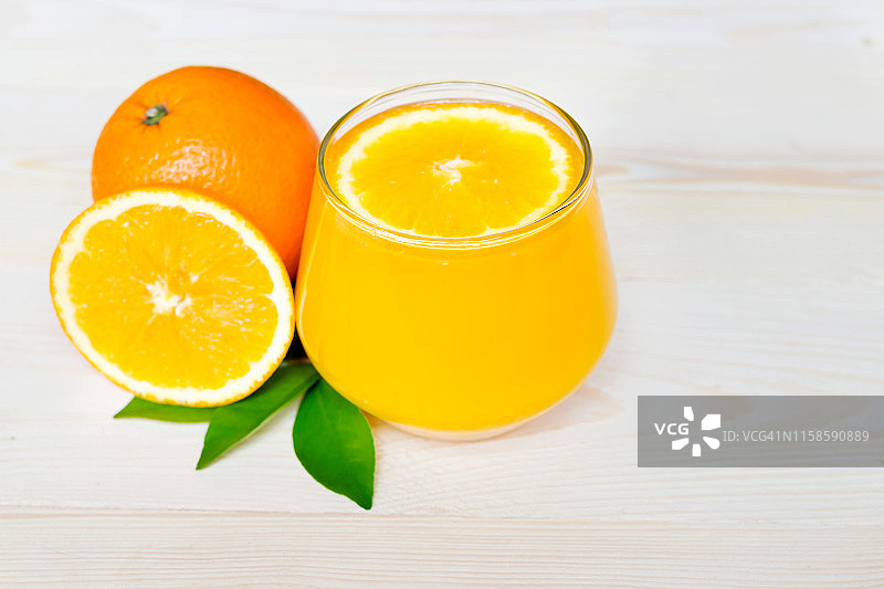 脐橙汁和橙片与树叶，木质背景图片素材