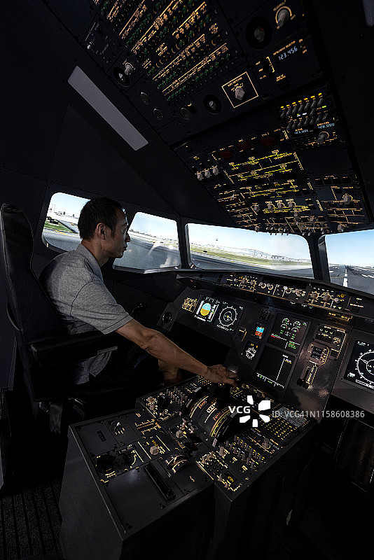体验飞机驾驶舱的亚洲男子图片素材
