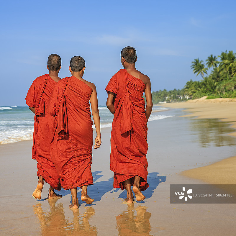 斯里兰卡青年佛教僧侣在海滩上行走图片素材