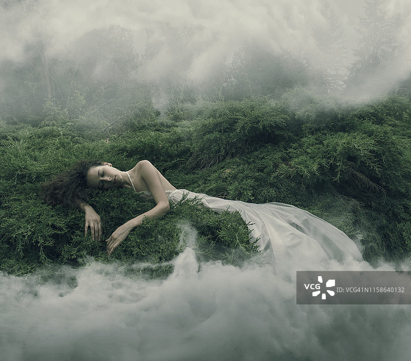 在雾蒙蒙的灌木丛中休息的妇女图片素材
