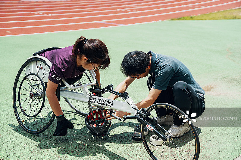 年轻的轮椅赛车手在父母或教练的支持下准备比赛图片素材