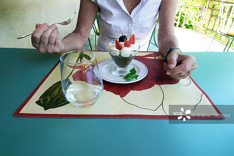 年长妇女在餐桌上吃甜点图片素材