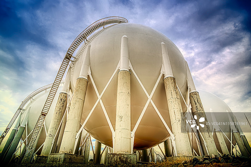 炼油厂蓝色天空下的球形储气罐图片素材