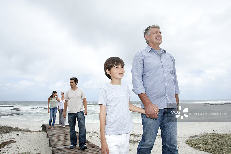 在海滩木制码头上行走的三代同堂家庭图片素材