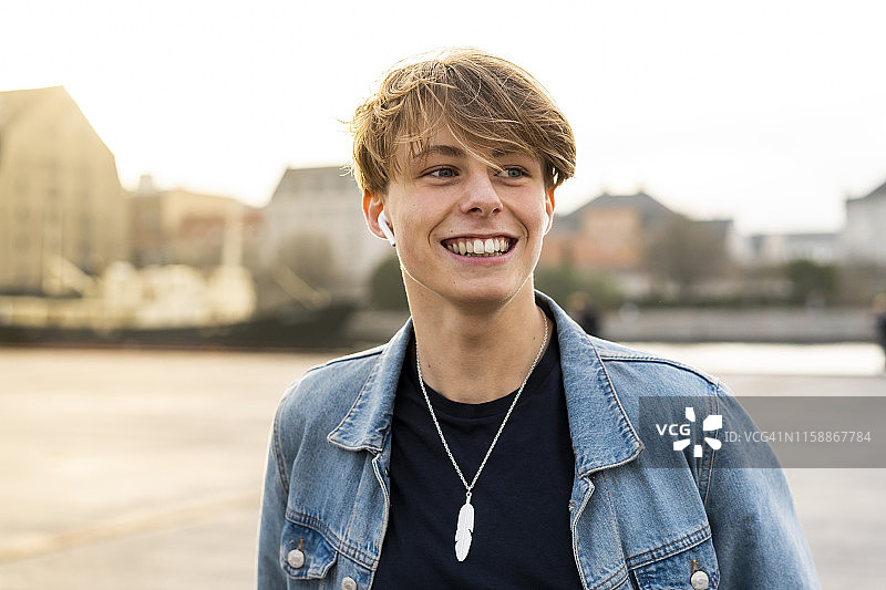 丹麦哥本哈根：在城市里戴着耳机快乐的年轻人图片素材