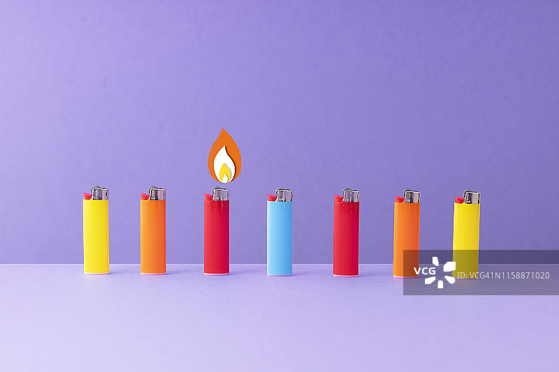 紫色背景下排列的彩色打火机图片素材