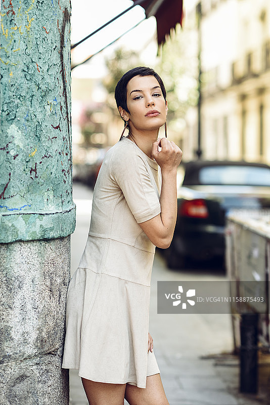 身穿连衣裙的时尚年轻女子在城市里图片素材
