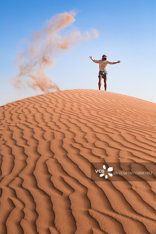 阿曼苏丹国，瓦希巴沙，中年男子在沙漠中玩沙子图片素材