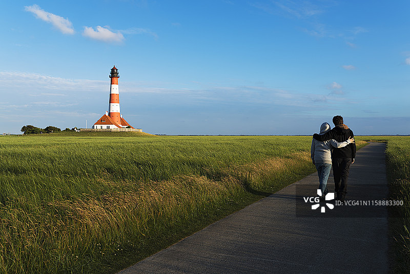 德国韦斯特海弗：情侣在灯塔旁漫步图片素材
