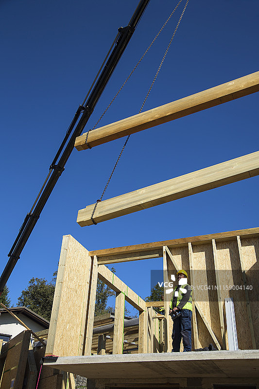 男子在建筑工地控制起重机图片素材