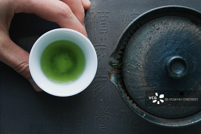 俯视：女人手端着一小杯冰镇焙茶图片素材