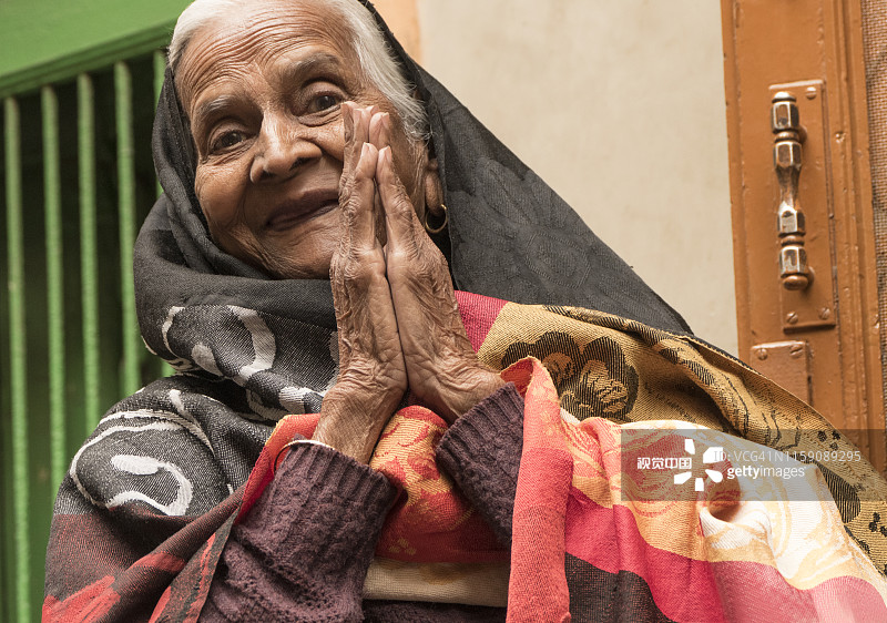 在印度德里，一位快乐的印度教传统老年妇女为我祈福图片素材