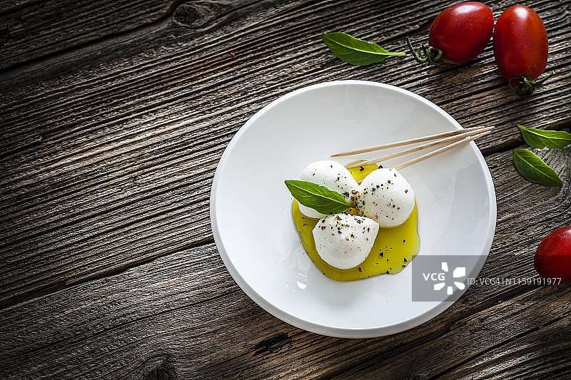 意大利美食：乡村木桌上的莫扎里拉小奶酪开胃菜图片素材