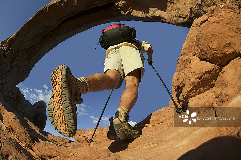 岩石拱门下的靴子底部和徒步旅行者图片素材