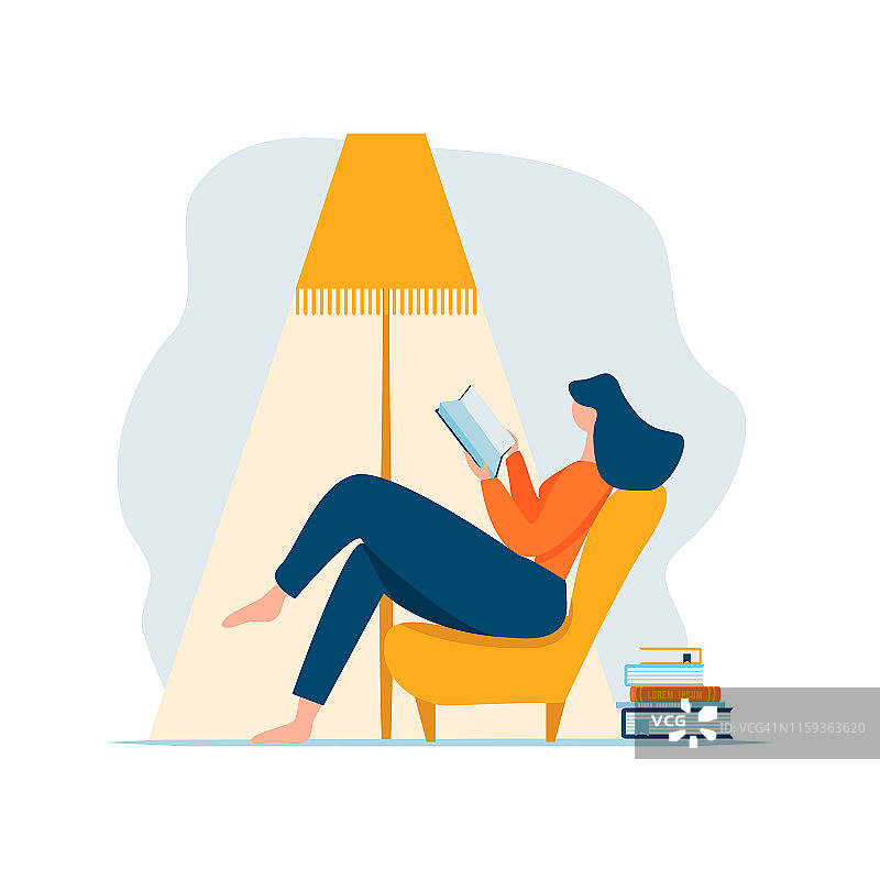 年轻女子坐在椅子上，在灯下和书堆旁读书放松图片素材