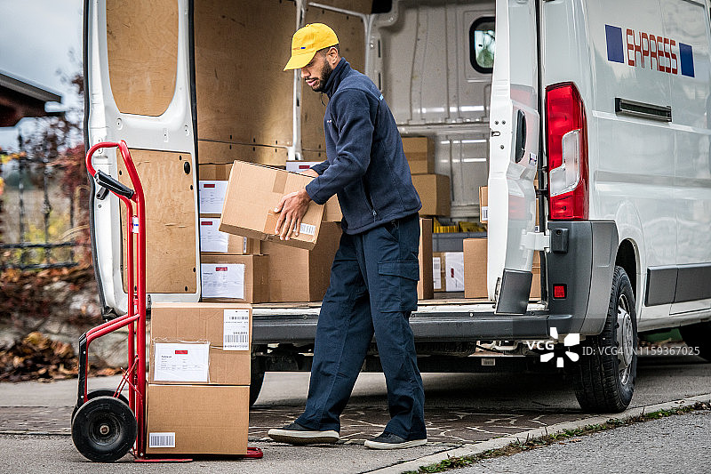 外卖员将包裹堆放在手推车上图片素材