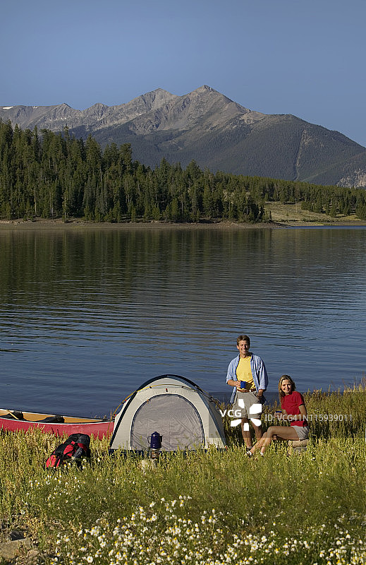 情侣在山间湖畔营地喝咖啡图片素材