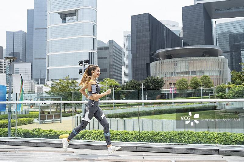 在桥上跑步的苗条女运动员图片素材