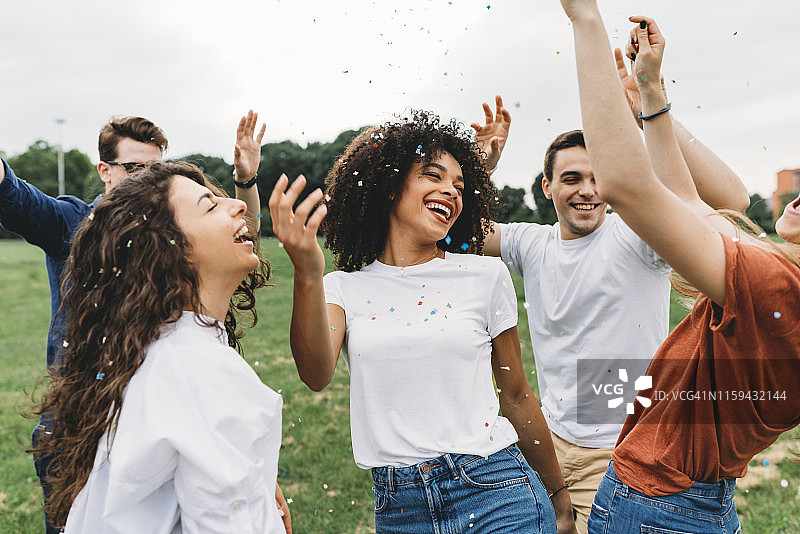 朋友们在公园里一起玩耍，撒着五彩纸屑图片素材