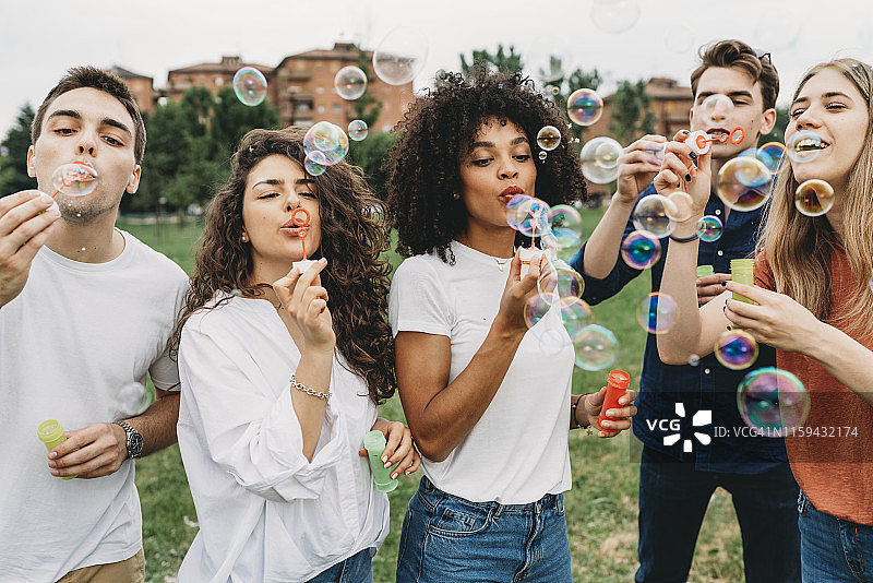 朋友们在公园一起吹泡泡玩耍图片素材