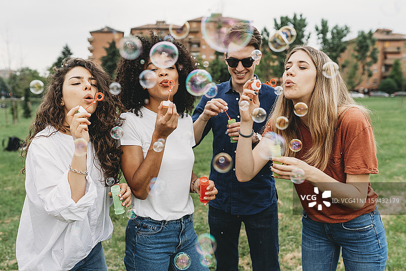 朋友们在公园一起吹泡泡玩耍图片素材