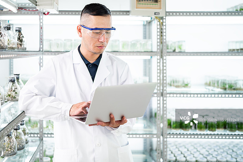 在实验室使用笔记本电脑的男科学家图片素材