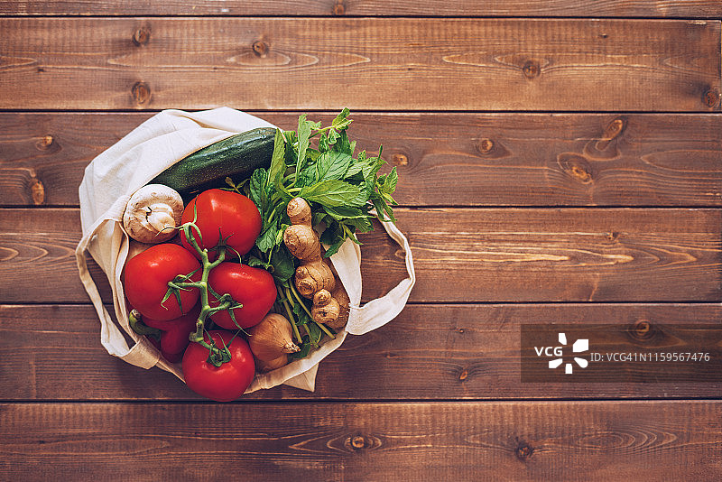 木质背景上的可重复使用棉布蔬菜袋图片素材
