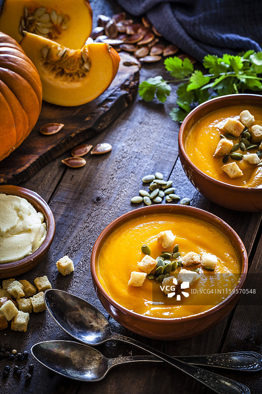 乡村木桌上的南瓜汤与配料图片素材