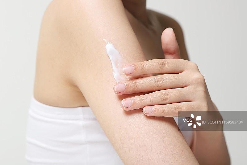 女人在手臂上涂抹润肤露图片素材