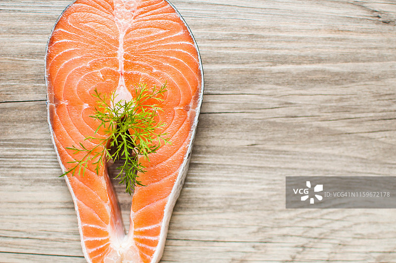木桌上用莳萝装饰的生三文鱼排图片素材