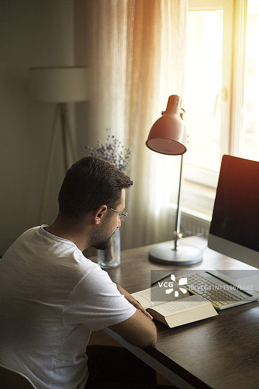 男人在桌子旁看书图片素材