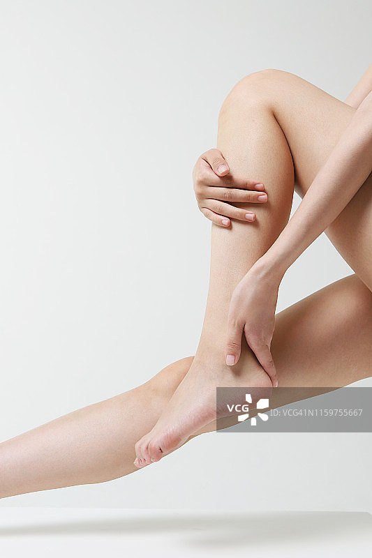 年轻女人按摩腿部图片素材