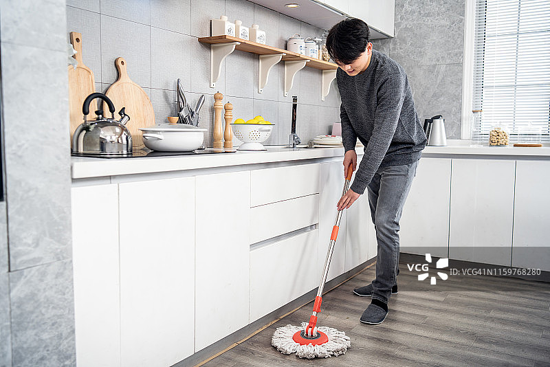 年轻男人在拖地图片素材