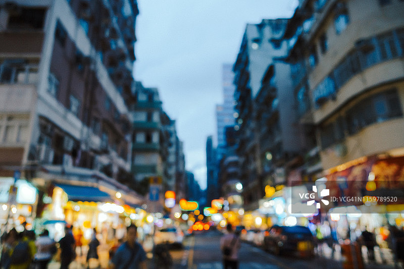 繁忙的城市街道与当地市场摊位的虚焦图像。游客和当地人在中国香港旺角购物和游览图片素材