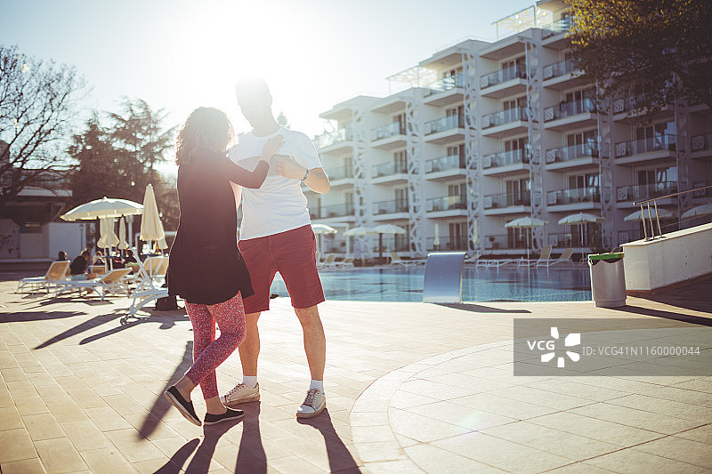 情侣在酒店泳池旁跳舞图片素材