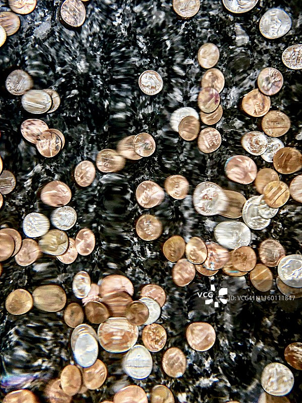 硬币喷泉底部的便士和角币图片素材