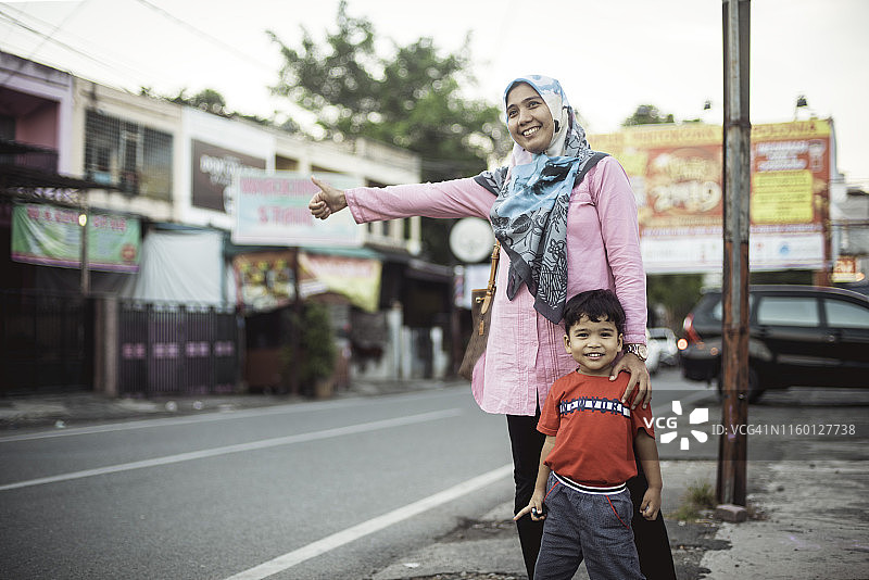 穆斯林女人和孩子街边等出租车图片素材