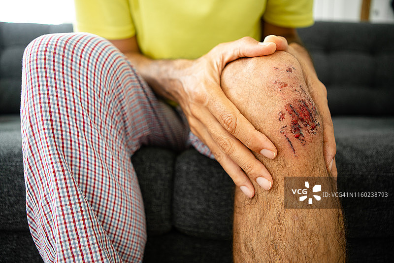 男子手扶受伤的膝盖图片素材