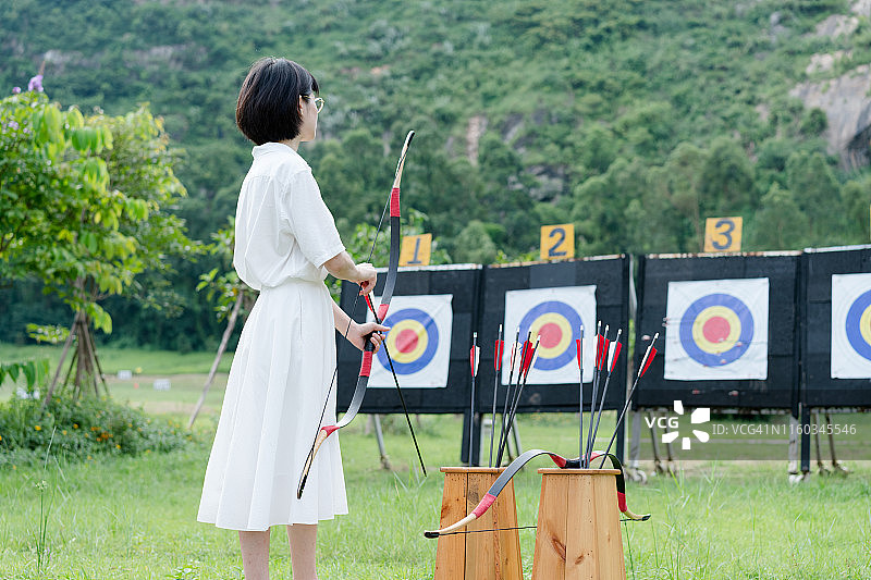 在户外练习射箭的亚洲女性图片素材