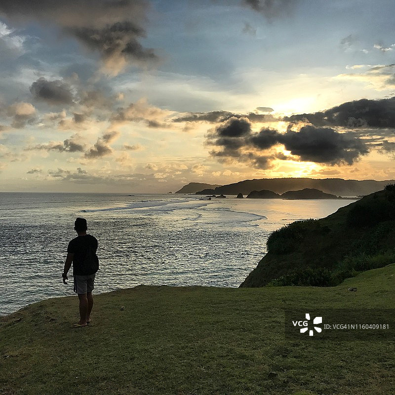 山坡海边云层后的阳光射线图片素材