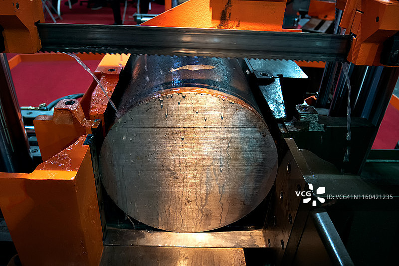 用于工业切割金属棒的带锯和冷却剂，高科技加工概念图片素材