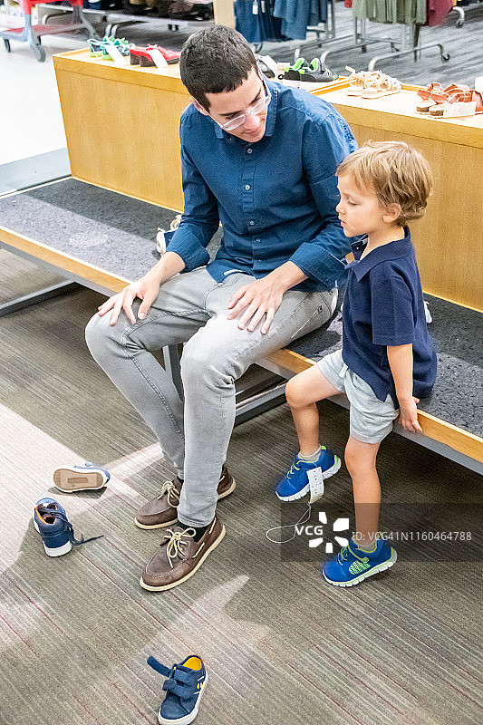 年轻男人为儿子买鞋图片素材
