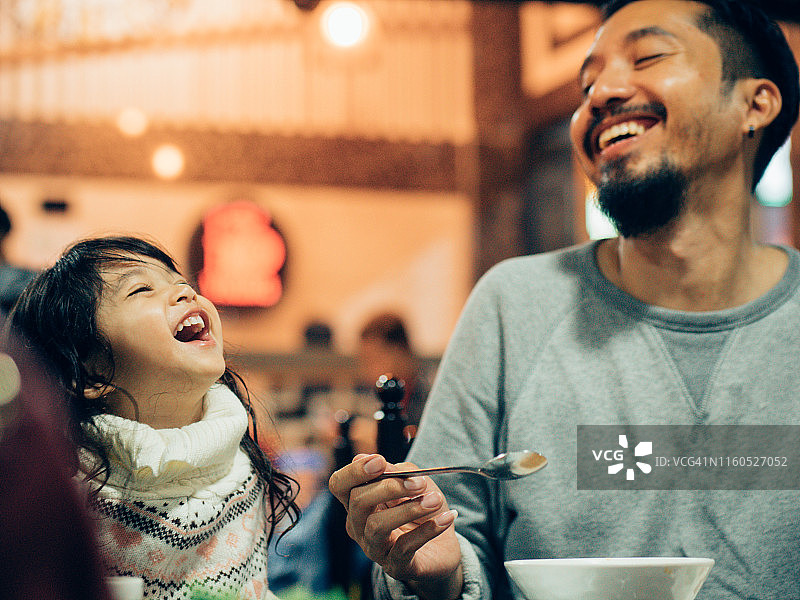亚洲时髦的父亲和女儿在餐厅吃韩国烤肉自助餐图片素材