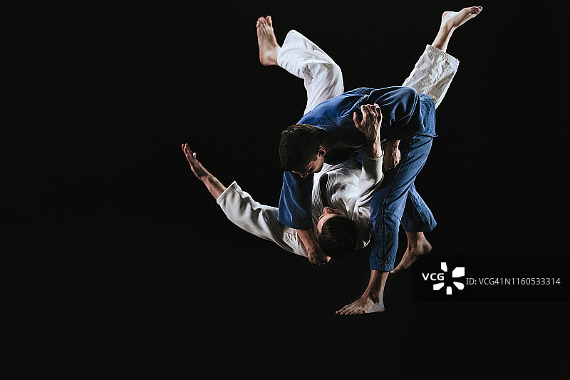 男性柔道家将他的伙伴摔倒在地图片素材