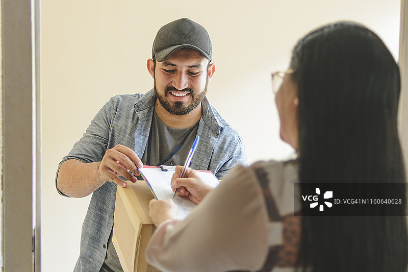 女人签署包裹的送货单图片素材
