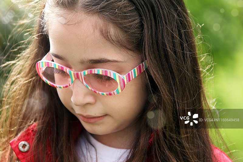 阳光花园中的小学生女孩肖像图片素材