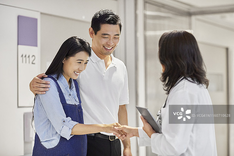 医生迎接孕妇及其丈夫图片素材