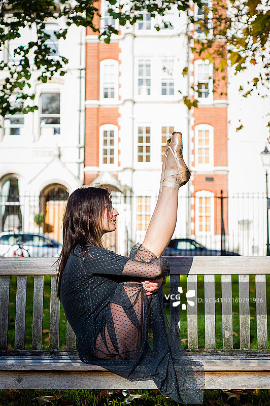 芭蕾舞者在长凳上伸展图片素材