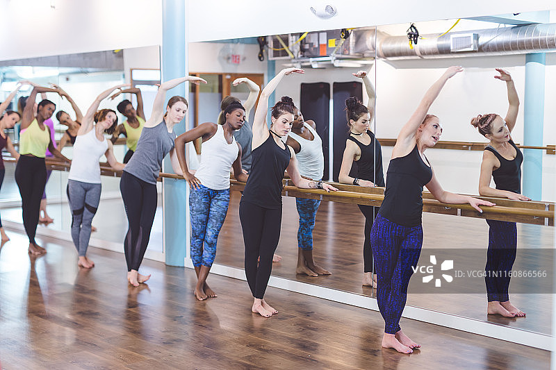 在现代健身工作室一起做芭蕾健身操的各民族女性图片素材