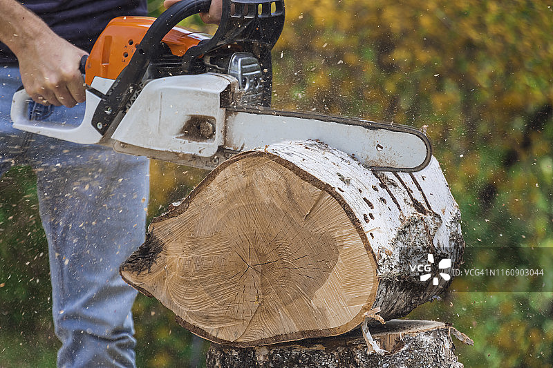 男子用电锯切割木头的下半身图片素材
